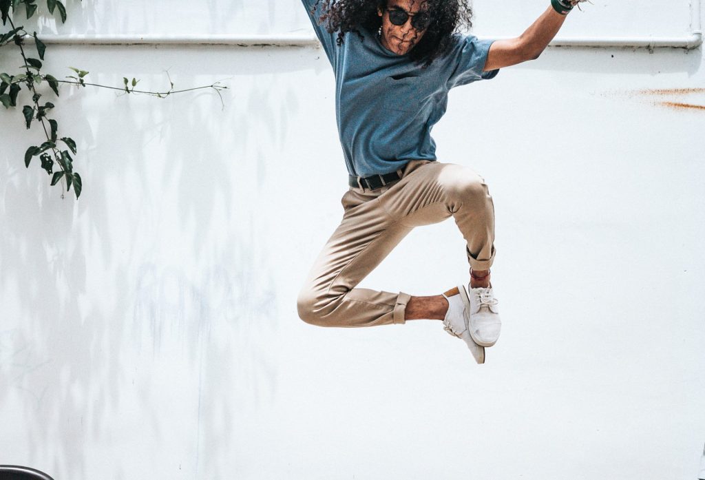 Man jumping up with feet together and white background