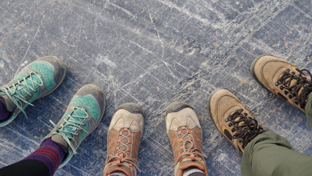 three pairs of shoes wearing hiking boots