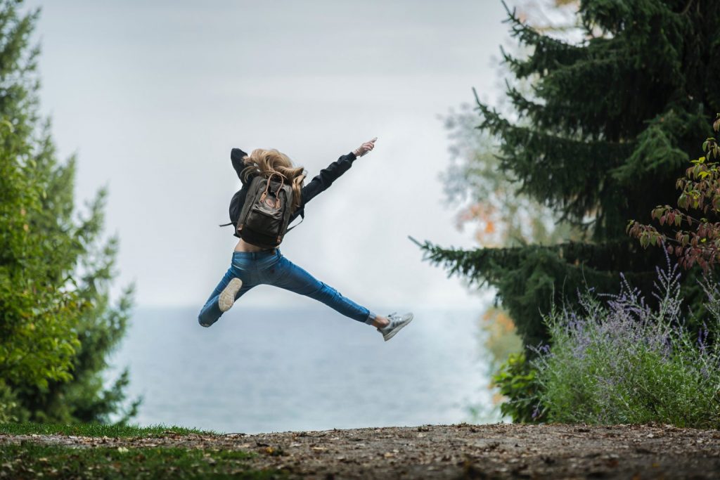 Woman jumping in air outside on trail