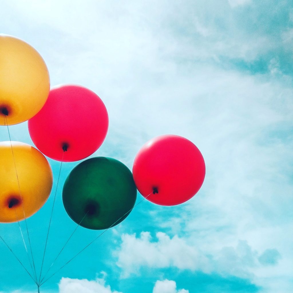 Five assorted balloons with sky as background