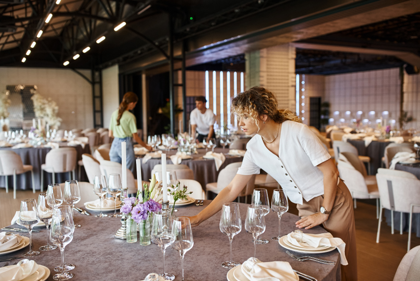 An event planning team putting the finishing touches on a small gala-style dinner event.